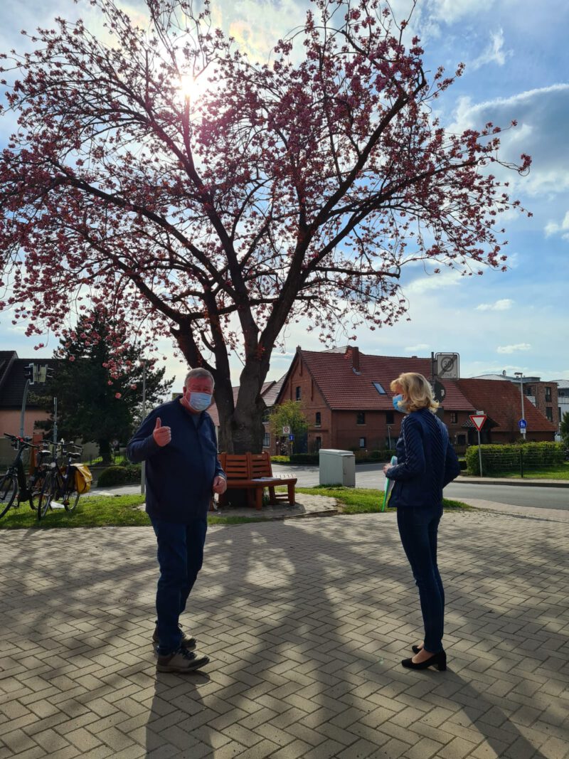 Herr Künecke und Frau Lange vor einem blühenden Kirschbaum